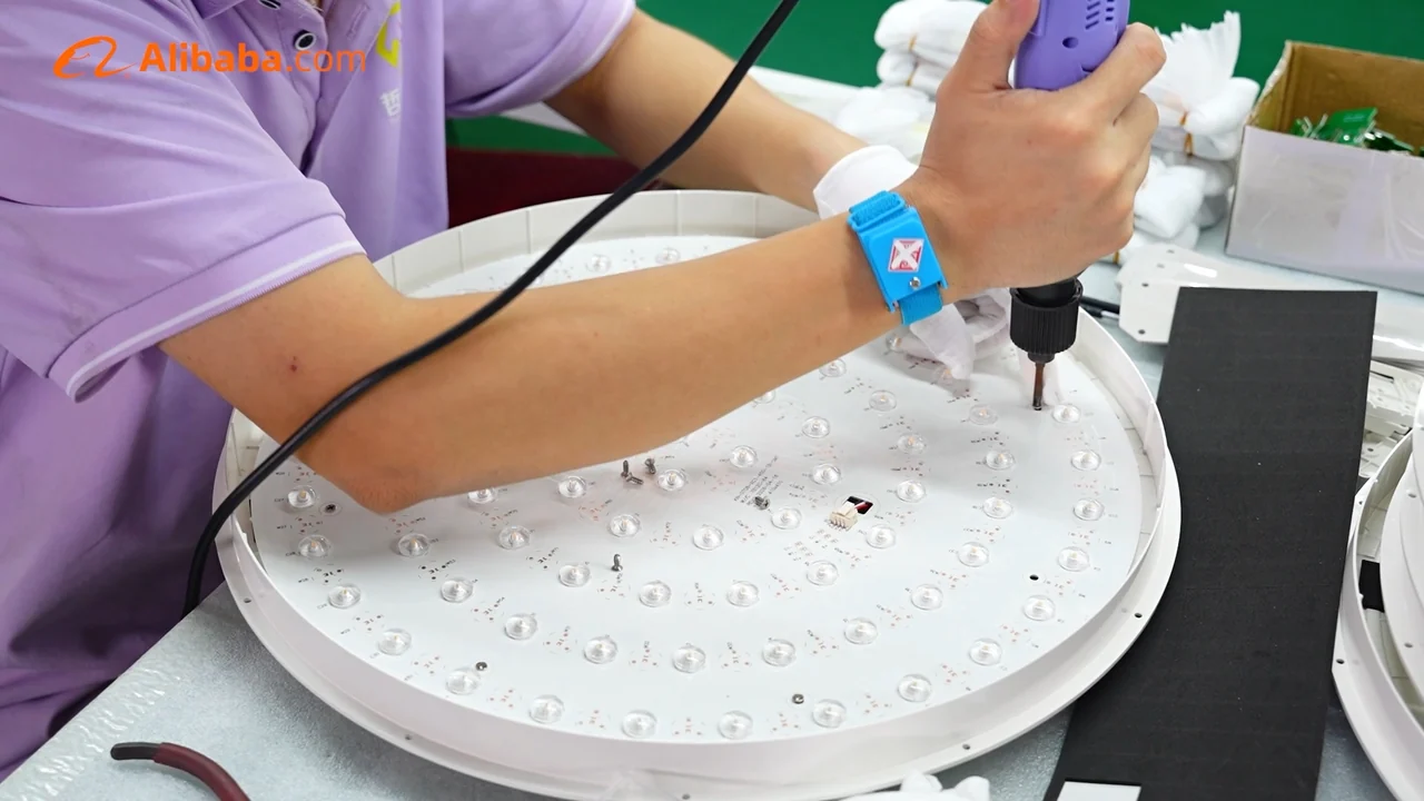 Ein Zhexian-Mitarbeiter befestigt eine LED-Platine bei der Leuchtenmontage.