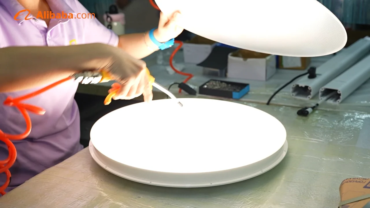 A Zhexian worker inspecting an illuminated ceiling light.